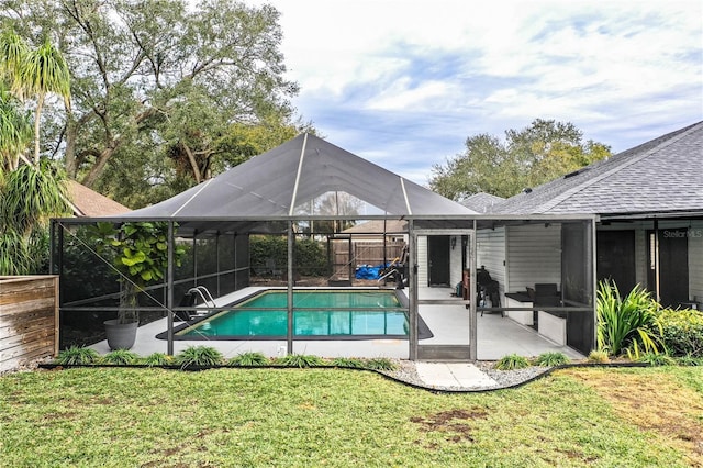 view of pool with a yard, a patio area, and glass enclosure