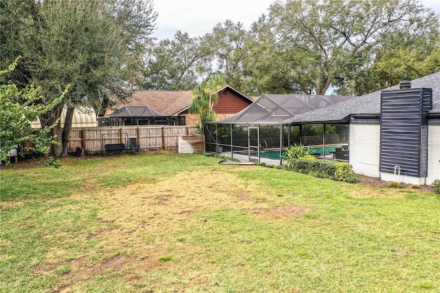 view of yard featuring a fenced in pool and glass enclosure