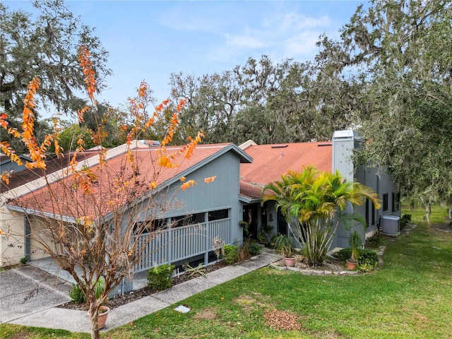 back of property with cooling unit and a lawn