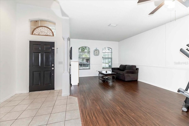 entryway featuring ceiling fan, light wood-type flooring, and decorative columns