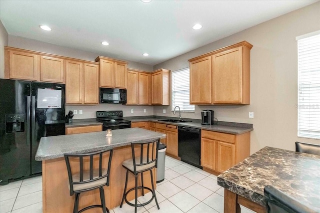 kitchen featuring light tile patterned floors, a kitchen island, sink, and black appliances