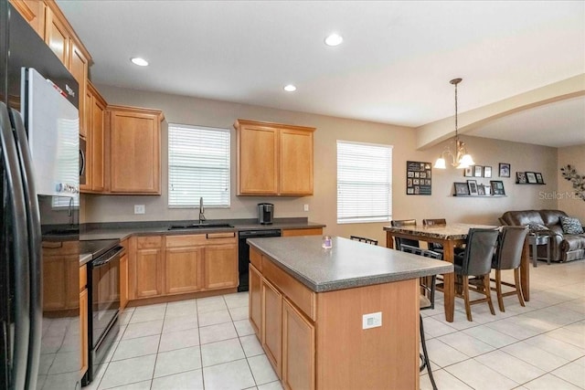 kitchen with black appliances, a kitchen island, an inviting chandelier, plenty of natural light, and sink