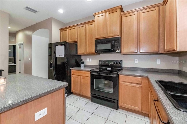 kitchen with black appliances, sink, and light tile patterned flooring