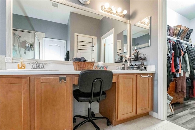 bathroom featuring a shower with shower door, vanity, and tile patterned flooring