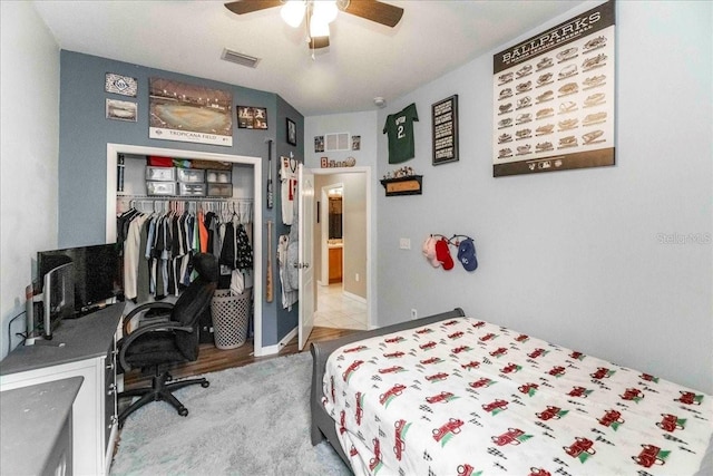 carpeted bedroom with ceiling fan and a closet