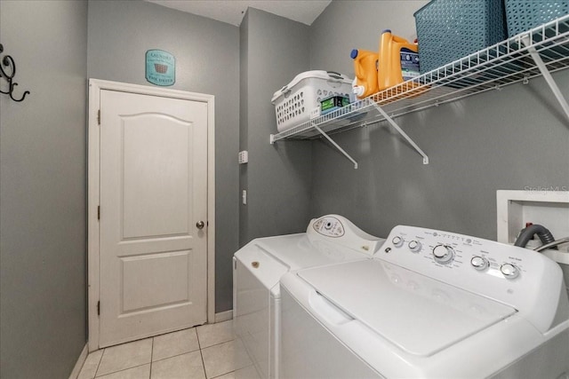 laundry area featuring light tile patterned floors and washer and clothes dryer