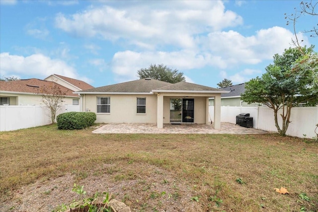 rear view of property with a lawn and a patio area