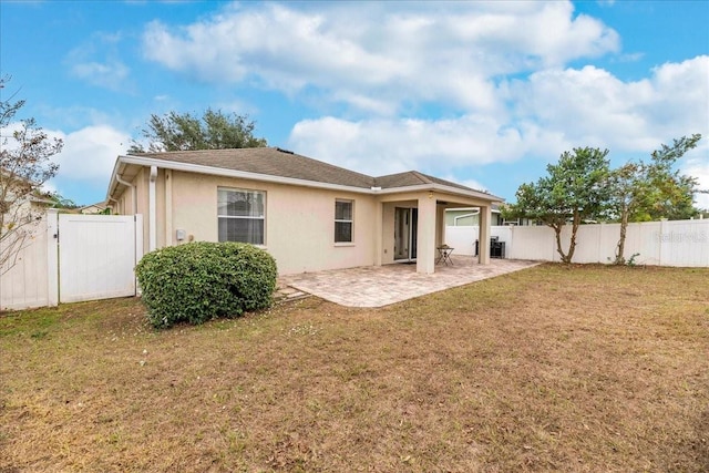 rear view of property featuring a lawn and a patio