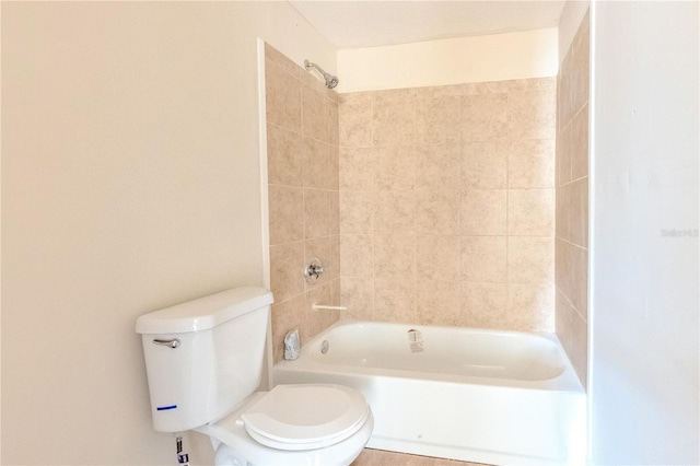 bathroom with toilet and tiled shower / bath