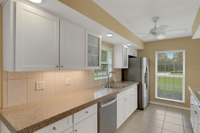 kitchen with sink, stainless steel appliances, white cabinets, and tasteful backsplash