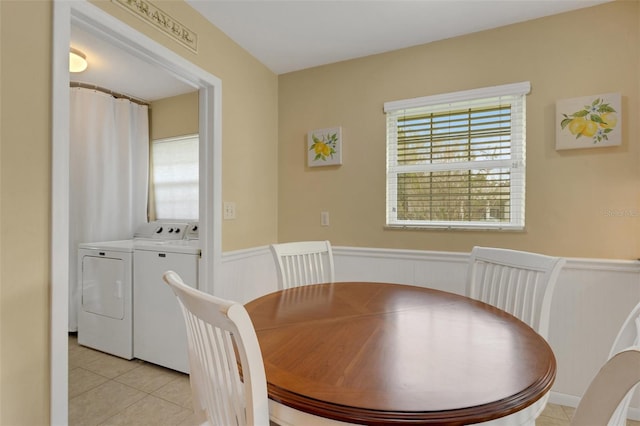 tiled dining room with separate washer and dryer