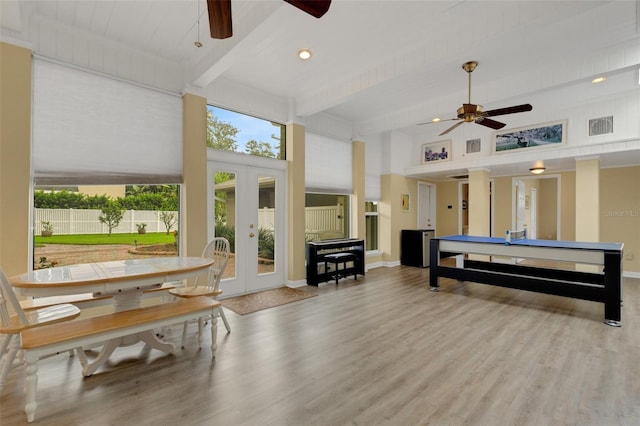 playroom featuring a towering ceiling, french doors, ceiling fan, light hardwood / wood-style flooring, and beam ceiling