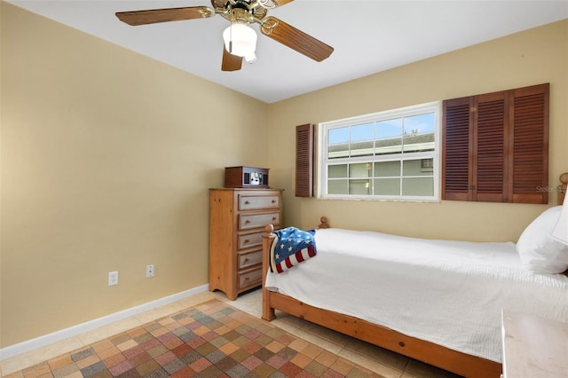 tiled bedroom featuring ceiling fan