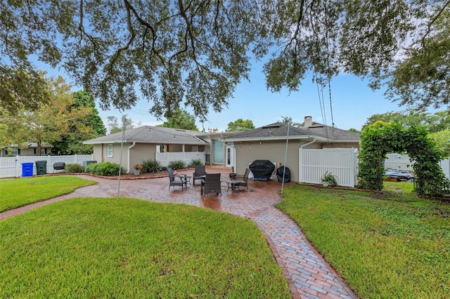 back of property with a patio area and a yard