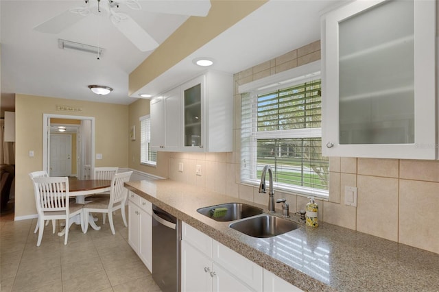 kitchen featuring dishwasher, sink, white cabinetry, tasteful backsplash, and light tile patterned flooring