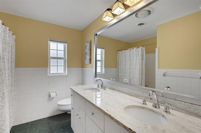 bathroom with tile walls, toilet, vanity, and tile patterned flooring