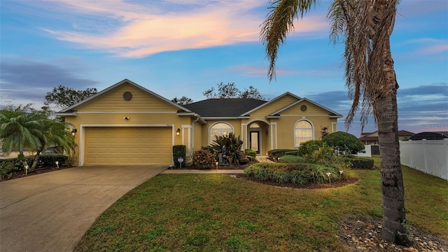 ranch-style home with a garage and a lawn