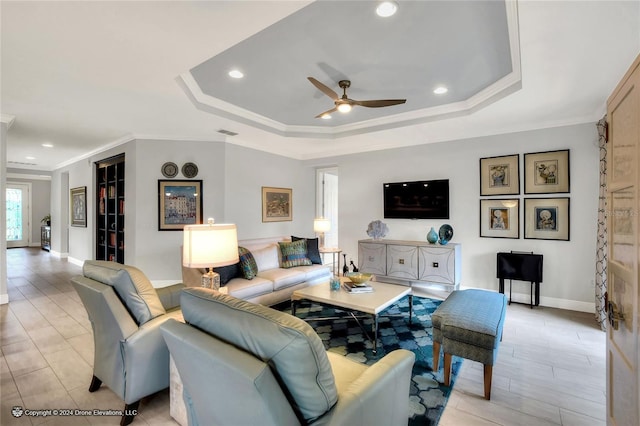 living room featuring ceiling fan, crown molding, and a raised ceiling