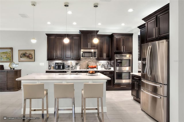 kitchen with hanging light fixtures, a center island with sink, stainless steel appliances, and a breakfast bar area