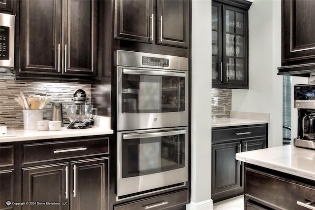 kitchen featuring appliances with stainless steel finishes, dark brown cabinets, and tasteful backsplash