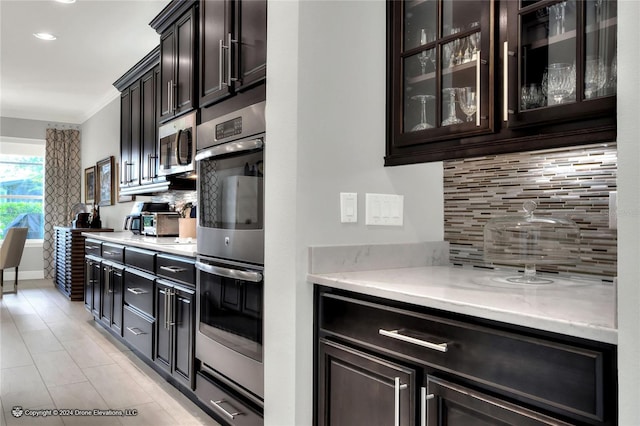 kitchen with backsplash, appliances with stainless steel finishes, and crown molding