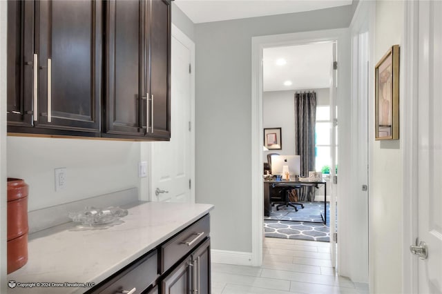 interior space with light stone countertops and dark brown cabinetry