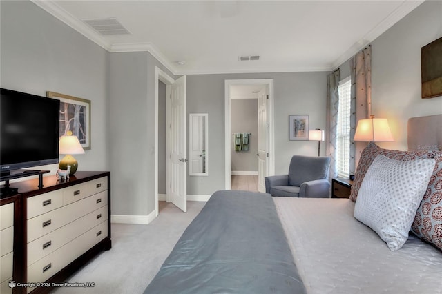 carpeted bedroom featuring crown molding and ensuite bath