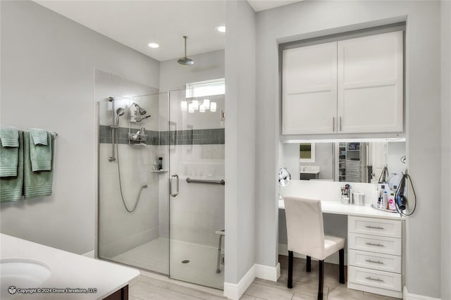 bathroom featuring tile patterned flooring, a shower with door, and vanity