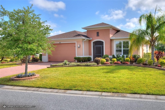 mediterranean / spanish-style house featuring a front yard and a garage