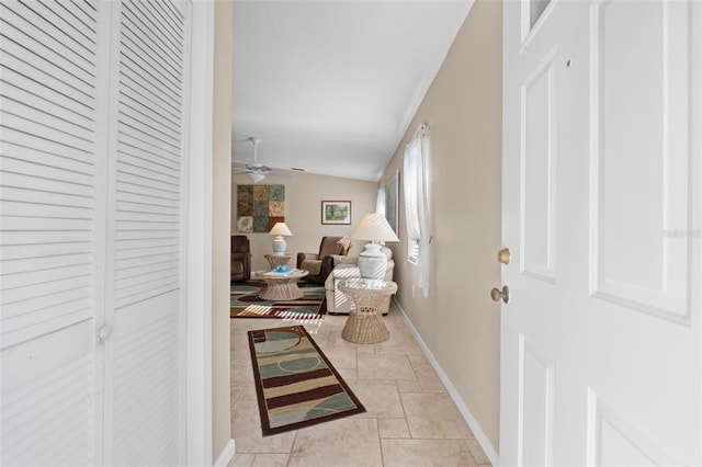 tiled living room with ceiling fan and lofted ceiling