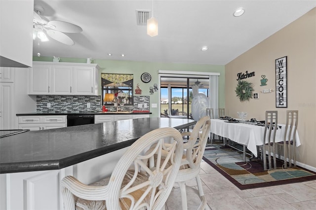 kitchen with white cabinets, black dishwasher, backsplash, ceiling fan, and light tile patterned floors