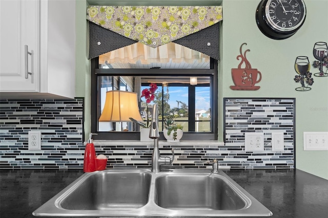 kitchen with decorative backsplash, sink, and white cabinetry