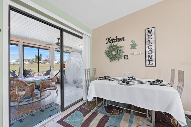 tiled dining room with ceiling fan and lofted ceiling