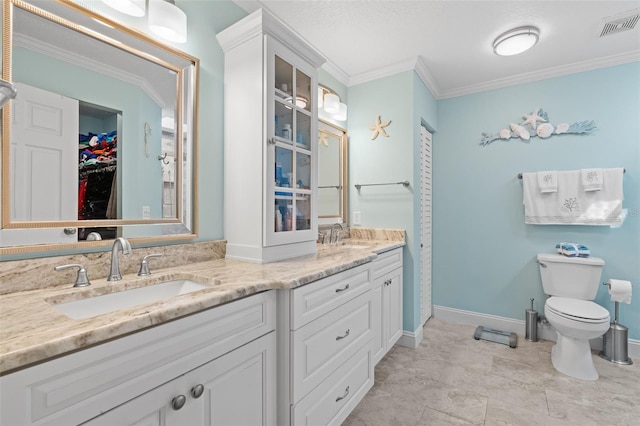 bathroom featuring toilet, vanity, and ornamental molding