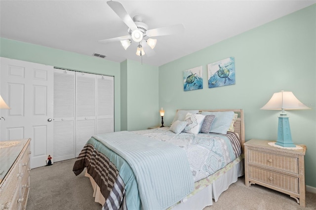 bedroom featuring ceiling fan, light colored carpet, and a closet