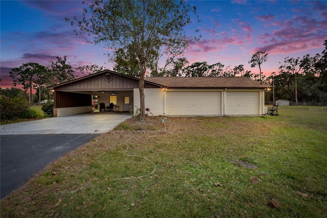 ranch-style house with a lawn, a carport, and a garage