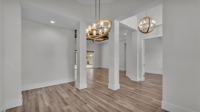 unfurnished dining area featuring light hardwood / wood-style flooring and a chandelier