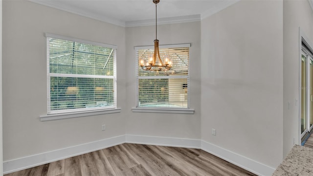 unfurnished dining area featuring crown molding, wood-type flooring, and a notable chandelier