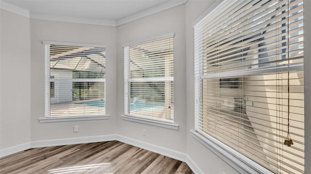 unfurnished room with hardwood / wood-style flooring and crown molding