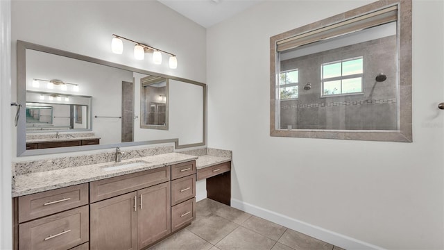 bathroom with tiled shower, tile patterned floors, and vanity