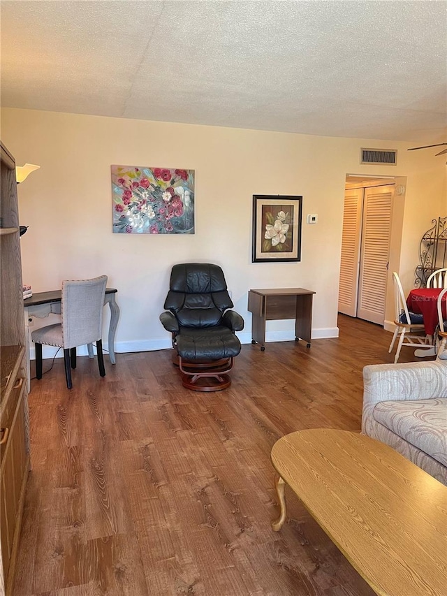 living room featuring dark hardwood / wood-style floors and a textured ceiling