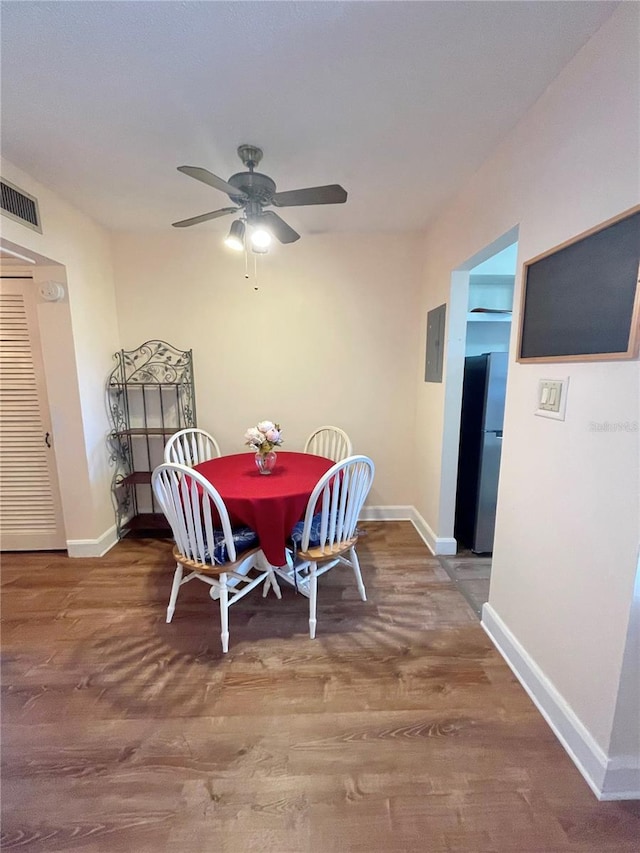 dining room with ceiling fan, hardwood / wood-style floors, and electric panel