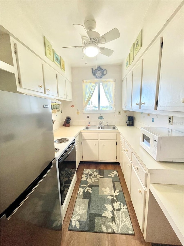 kitchen with white cabinets, sink, and white appliances