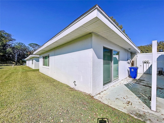 view of side of property featuring a yard and a patio