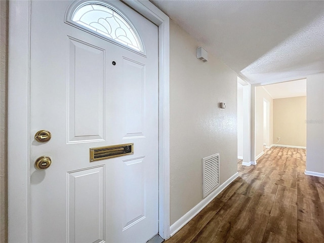 hall with dark hardwood / wood-style flooring and a textured ceiling