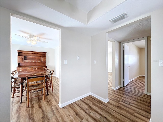 dining space with ceiling fan and hardwood / wood-style floors