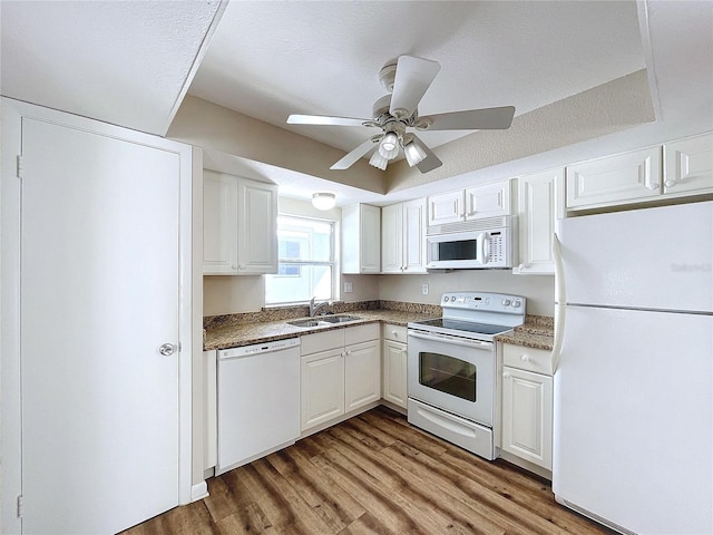 kitchen featuring a textured ceiling, white cabinetry, sink, and white appliances