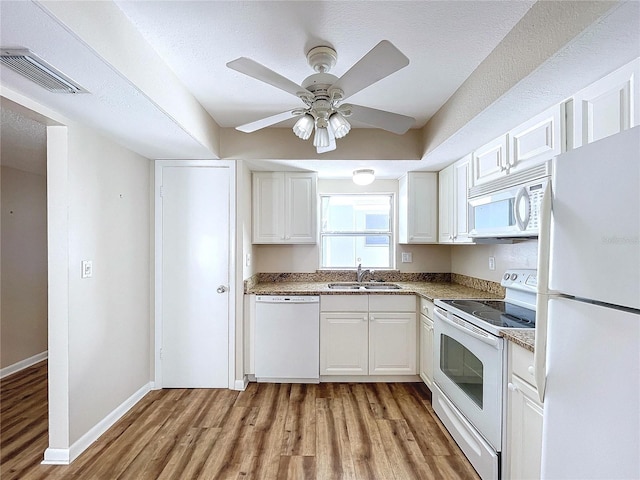 kitchen with white appliances, white cabinets, sink, ceiling fan, and light hardwood / wood-style flooring