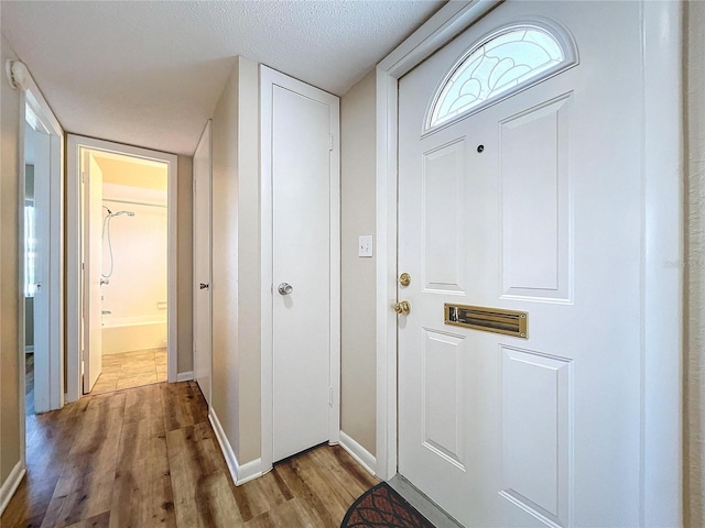 doorway to outside featuring a textured ceiling and hardwood / wood-style floors