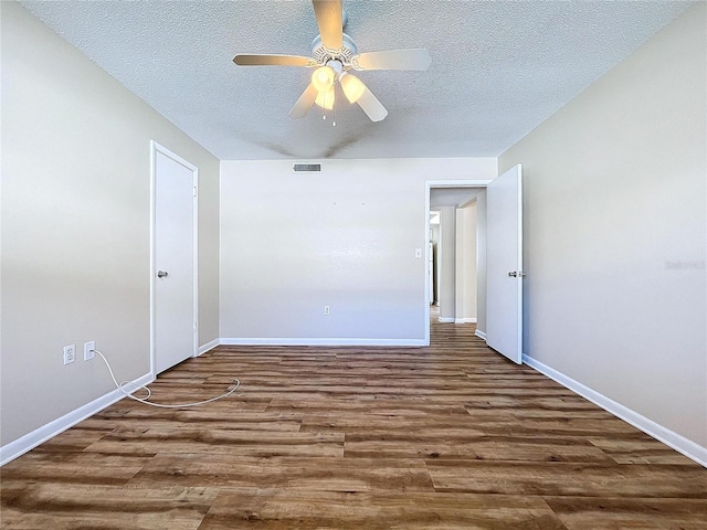 empty room featuring dark wood-type flooring, ceiling fan, and a textured ceiling